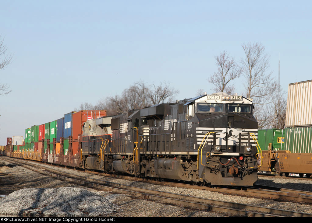 NS 8115 leads a long cut of cars out of the yard
